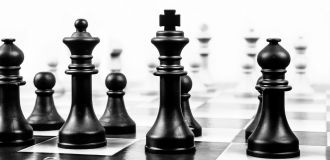 Schachfiguren Schwarz und weiß vor weißem Hintergrund